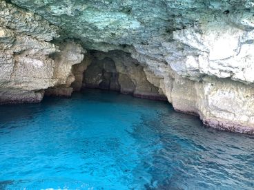 A stunning view of a natural cave with crystal-clear turquoise waters, perfect for exploring coastal wonders and enjoying serene moments on the water.