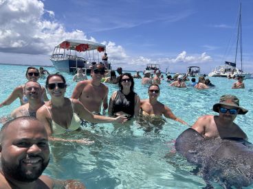 A lively group enjoys a memorable day swimming with stingrays in crystal-clear waters, creating unforgettable beach memories.