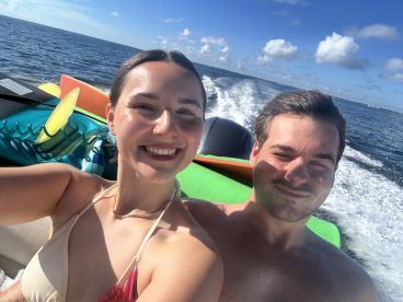 A happy couple enjoys a sunny day on the water, capturing a joyful moment while boating — perfect for adventure seekers and romantic getaways.