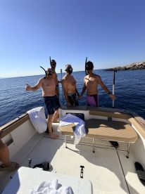 A group of friends prepares for a snorkeling adventure on a boat, showcasing excitement and camaraderie in the beautiful open water.