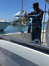 A man prepares to grill on a boat, showcasing onboard cooking amenities — perfect for enjoying meals at sea.