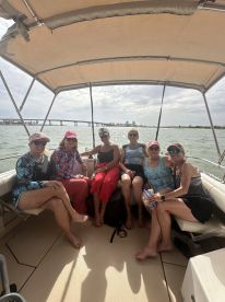 A joyful group of friends enjoys their time on a boat, capturing the essence of friendship and fun on the water.