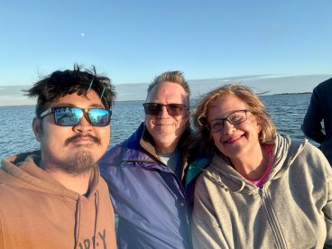 A cheerful group enjoys a moment together on a boat, capturing the joy of their outing against a scenic water backdrop.