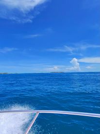 A stunning view of the ocean and distant islands under a bright blue sky, perfect for showcasing the beauty of a boating adventure.