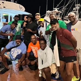 A lively group of friends poses for a fun photo at the marina, celebrating their time together — perfect for capturing memorable moments on a boating trip.