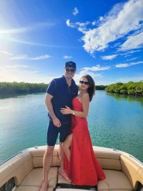 A couple enjoys a romantic moment on a boat, surrounded by serene waters and lush greenery — perfect for unforgettable getaways and celebrations.