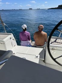 A couple enjoys a serene moment on the boat, gazing out at the ocean — perfect for romantic getaways or peaceful retreats on the water.