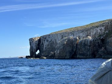 A stunning view of a natural rock formation along the coastline, showcasing the beauty of the landscape and the serene waters — perfect for nature lovers and sightseeing tours.