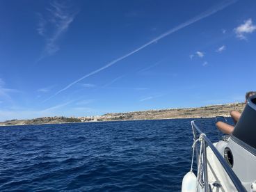 A scenic view of a coastline from a boat, showcasing the beautiful blue waters and land in the background — perfect for exploring the stunning landscapes while cruising.