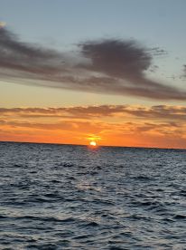 A stunning sunset over the ocean, showcasing vibrant colors reflecting on the water — perfect for serene evening boat cruises.