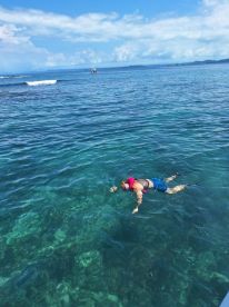 A snorkeler explores the vibrant underwater world in crystal-clear waters, showcasing the beauty of marine life and adventure on the water.