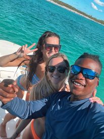 A joyful group takes a selfie on a boat, capturing a fun moment on the water — perfect for memorable boating adventures.