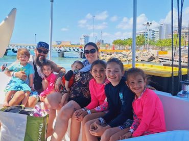 A joyful family poses together on a boat, capturing a fun moment during their aquatic adventure — perfect for family outings and memorable experiences on the water.
