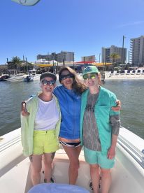 A joyful group of friends poses on the deck of a boat, ready for a day of fun on the water — perfect for creating lasting memories together.