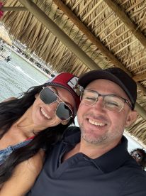 A happy couple enjoys a moment on a boat, capturing smiles against a scenic water backdrop — perfect for romantic outings or fun adventures on the water.