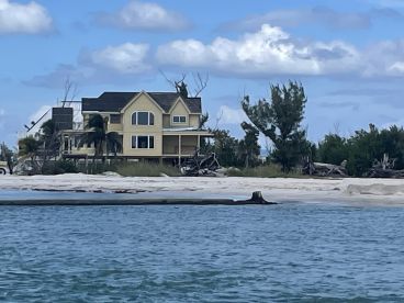 A view of a house near the shoreline, with unclear details and no visible people.