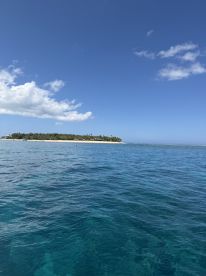 A stunning view of a tropical island with clear blue waters, perfect for showcasing beautiful coastal destinations and island adventures.