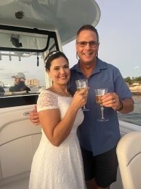 A joyful couple toasts with cocktails aboard a boat, perfect for celebrating special moments on the water.