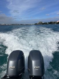 A dynamic view of twin Yamaha outboard motors cutting through the water, showcasing the thrill of speed on a beautiful day at sea.
