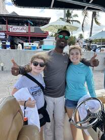 A joyful group poses on a boat, showcasing a fun day out on the water — perfect for family adventures or group outings.