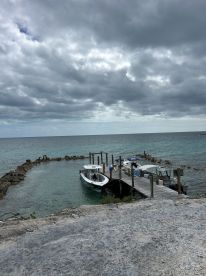 A scenic view of boats docked at a serene harbor, surrounded by calm waters and cloudy skies, perfect for a day of exploration.