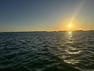 A stunning sunset over the tranquil waters, showcasing the beautiful coastline — perfect for romantic evenings or peaceful boat trips.