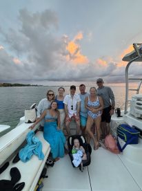 A joyful family gathers on a boat at sunset, capturing a memorable moment together — perfect for family outings and celebrations on the water.