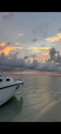 A serene view of a boat at sunset, showcasing the vessel's profile against a colorful sky — perfect for tranquil evening cruises.