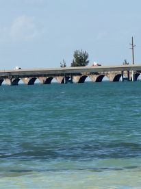 A distant view of a bridge over turquoise waters, with unclear details and no visible people.