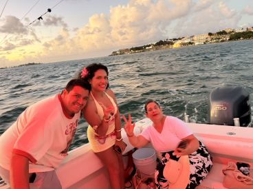 A joyful group enjoys a sunset boat ride, capturing fun moments and smiles against a beautiful backdrop — perfect for memorable celebrations on the water.