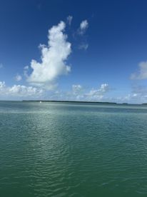 A scenic view of calm waters and clouds, but lacks clarity and identifiable subjects.
