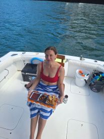A woman enjoys a delicious spread of snacks on a boat, perfect for a day of relaxation on the water.