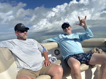 Two friends enjoy a relaxing day on the water, showcasing the perfect atmosphere for a fun boating adventure.