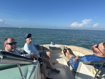 A group of friends relaxes on a boat, enjoying the serene ocean views — perfect for a day of leisure on the water.