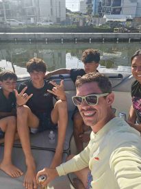 A joyful group of friends and family enjoy a sunny day on the boat, capturing fun moments and smiles — perfect for memorable outings on the water.