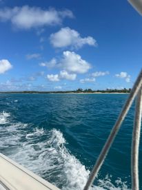 A picturesque view of the coastline from a boat, showcasing vibrant blue waters and a clear sky — perfect for capturing the essence of a relaxing day on the water.