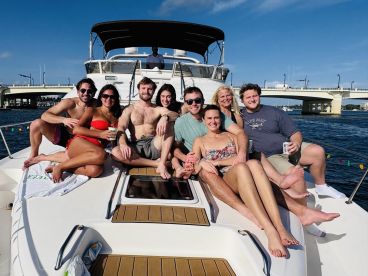A lively group of friends enjoys a sunny day on a yacht, capturing the essence of fun and celebration on the water.