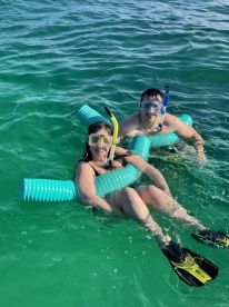 A couple enjoys snorkeling in crystal-clear waters, showcasing the fun and adventure of underwater exploration.