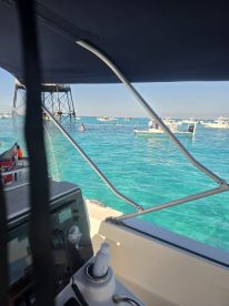 A vibrant scene from the helm of a boat, showcasing various water activities and boats in the turquoise waters — perfect for exploring the beauty of the ocean.