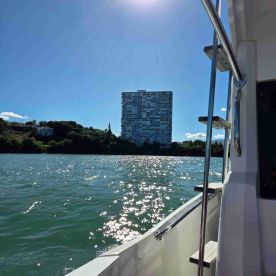 A scenic view from a boat showcasing a modern building against a sparkling water backdrop, perfect for capturing the essence of a relaxing day on the water.