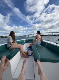 Two friends relax on a boat, enjoying the scenic views and the open water — a perfect moment for a day out on the water.