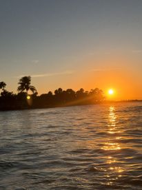 A breathtaking sunset over the coastline, reflecting golden hues on the water — a perfect moment for relaxation and appreciation of nature's beauty.