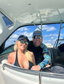 A cheerful couple enjoys their time aboard a boat, showcasing the perfect blend of sun and fun on the water.
