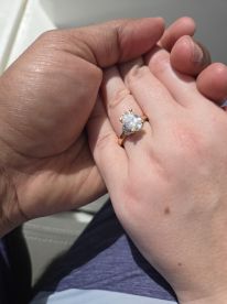 A romantic moment captured as a couple shares an engagement ring aboard a boat, perfect for memorable proposals on the water.