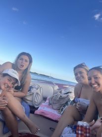 A group of friends enjoying drinks and laughter on a boat, capturing the essence of a fun day on the water.