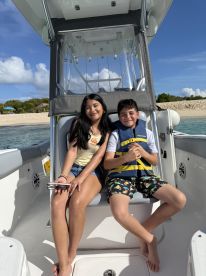 Two children enjoy a sunny day on a boat, showcasing the fun and excitement of family adventures on the water.