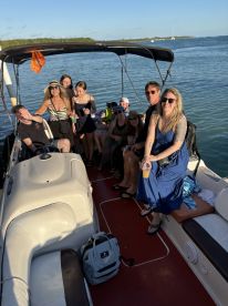 A lively group enjoys drinks and camaraderie aboard a boat, perfect for celebrations and memorable outings on the water.
