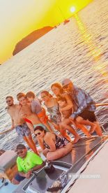 A joyful group poses together on a boat at sunset, capturing a memorable family moment on the water — perfect for celebrations and gatherings.