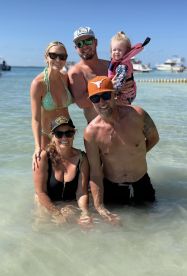A joyful family enjoys a sunny day at the beach, playing in the water and creating lasting memories together.