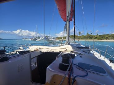 A view from the helm of a sailboat, showcasing the interior setup and the serene waters of a marina, perfect for sailing enthusiasts.